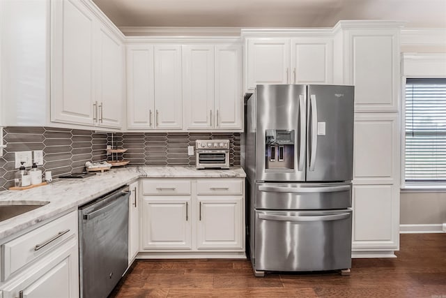 kitchen with light stone counters, white cabinetry, stainless steel appliances, and dark hardwood / wood-style floors