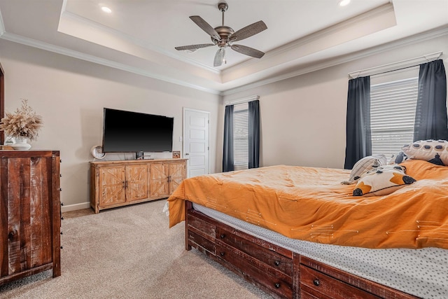 carpeted bedroom featuring a raised ceiling, ceiling fan, and ornamental molding