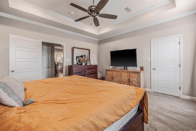 carpeted bedroom with ceiling fan, crown molding, and a tray ceiling