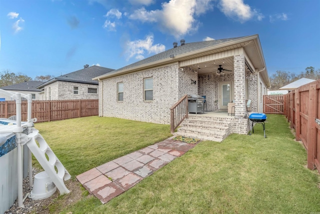 back of house featuring a yard and ceiling fan