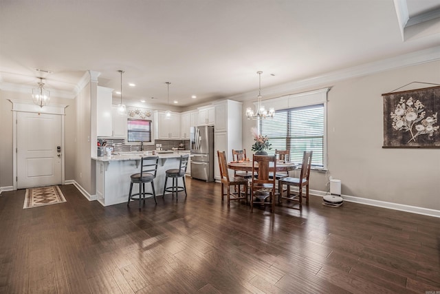 kitchen with pendant lighting, white cabinetry, stainless steel refrigerator with ice dispenser, and a breakfast bar area