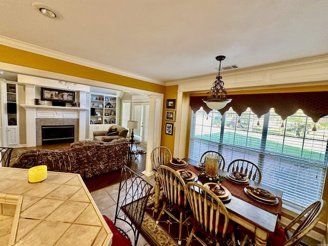 tiled dining space featuring built in shelves, ornamental molding, and a wealth of natural light