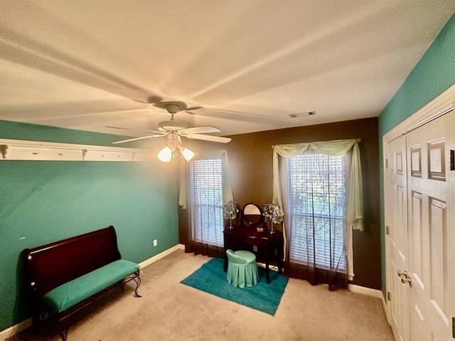 living area featuring carpet and ceiling fan