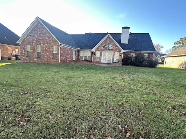 rear view of house featuring a yard