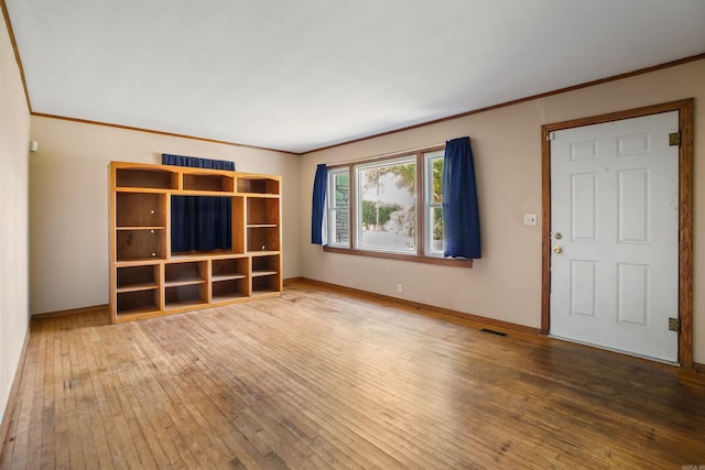 unfurnished living room with crown molding and wood-type flooring