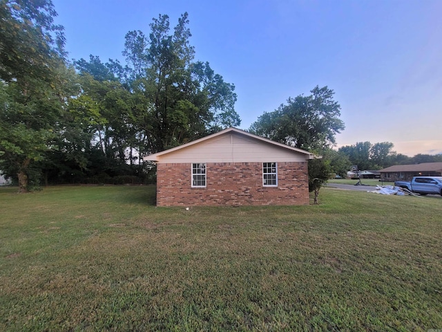 property exterior at dusk with a yard