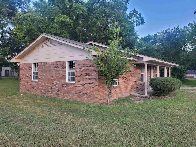 view of side of home with a yard