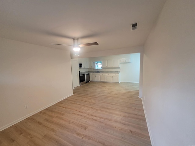 unfurnished living room with ceiling fan, light hardwood / wood-style floors, and sink