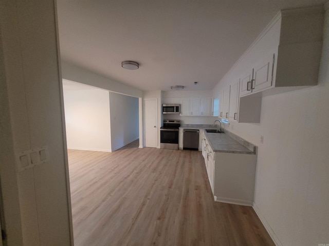 kitchen with white cabinetry, sink, light hardwood / wood-style floors, and appliances with stainless steel finishes