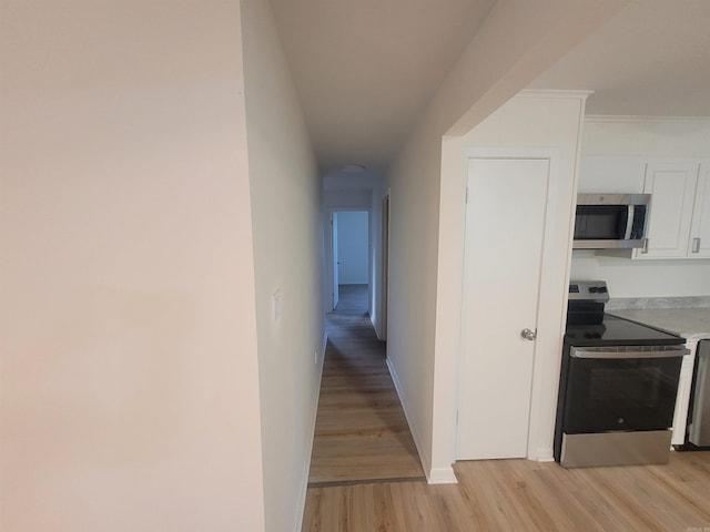 hall featuring ornamental molding and light wood-type flooring