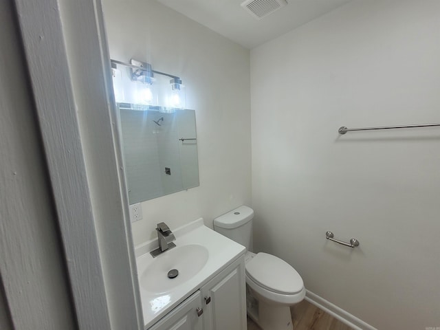 bathroom with hardwood / wood-style floors, vanity, and toilet