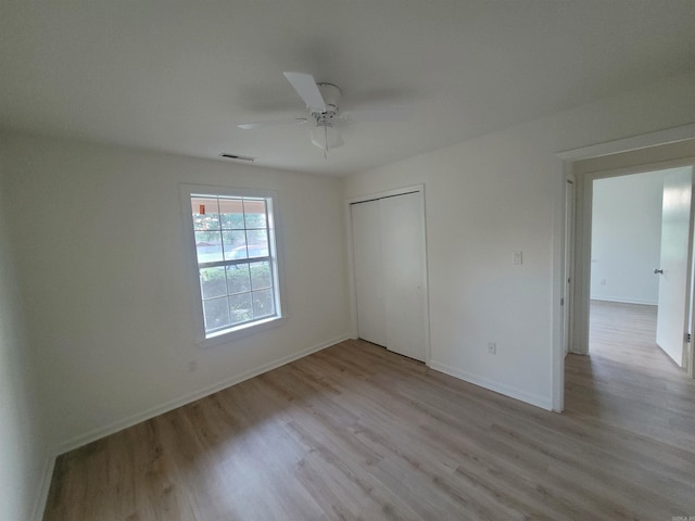 unfurnished bedroom with ceiling fan, light hardwood / wood-style floors, and a closet