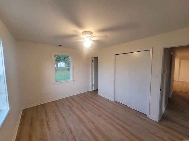 unfurnished bedroom with ceiling fan, a closet, and light wood-type flooring