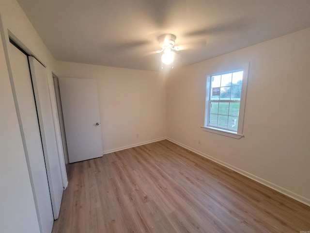 unfurnished bedroom with ceiling fan, a closet, and light hardwood / wood-style floors