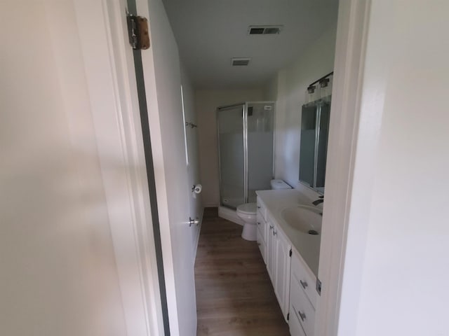 bathroom featuring vanity, hardwood / wood-style flooring, toilet, and an enclosed shower