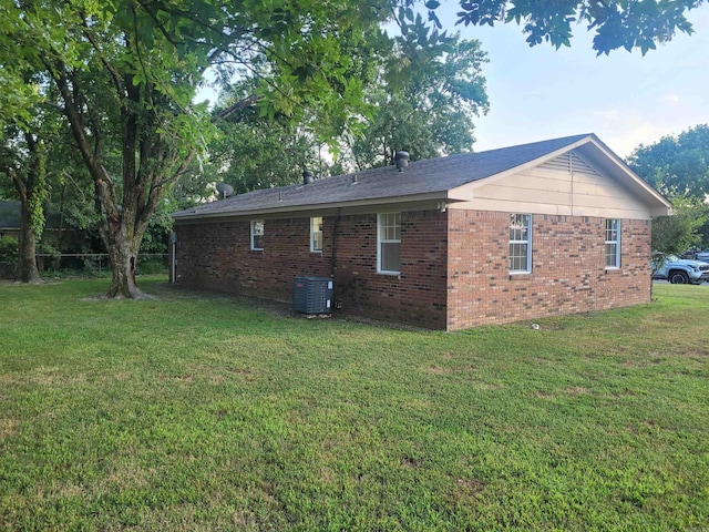 view of side of home with a lawn and central air condition unit