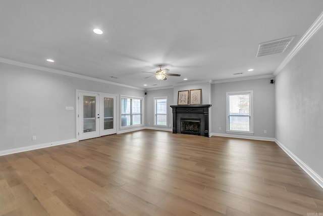 unfurnished living room featuring a tile fireplace, light hardwood / wood-style flooring, ceiling fan, and crown molding