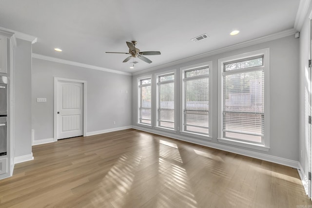 spare room featuring ceiling fan, crown molding, and a wealth of natural light