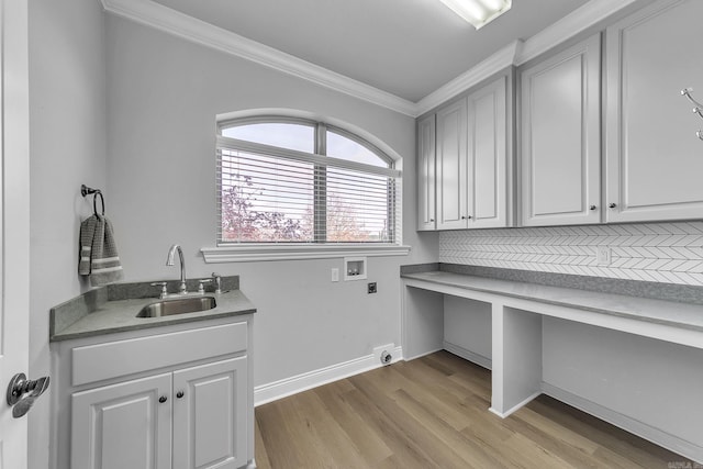 clothes washing area with electric dryer hookup, sink, hookup for a washing machine, ornamental molding, and light hardwood / wood-style floors