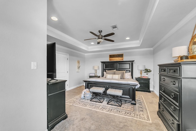 bedroom with light colored carpet, a tray ceiling, and ornamental molding