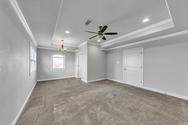 empty room with carpet flooring, ceiling fan with notable chandelier, crown molding, and a tray ceiling