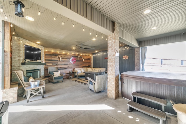 view of patio featuring an outdoor living space with a fireplace, ceiling fan, and a hot tub