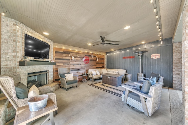 view of patio with an outdoor living space with a fireplace and ceiling fan