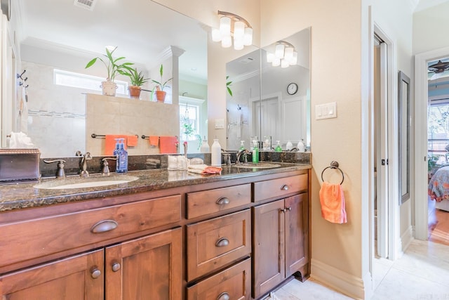 bathroom with a wealth of natural light, vanity, and ornamental molding