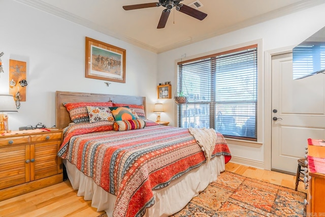 bedroom featuring ceiling fan, crown molding, and light hardwood / wood-style flooring