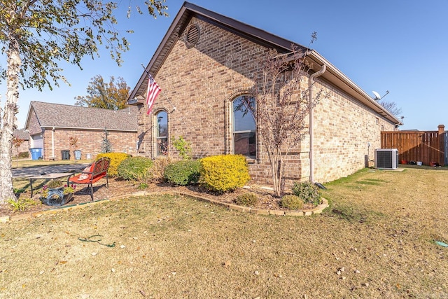 view of side of home with a lawn and central AC unit