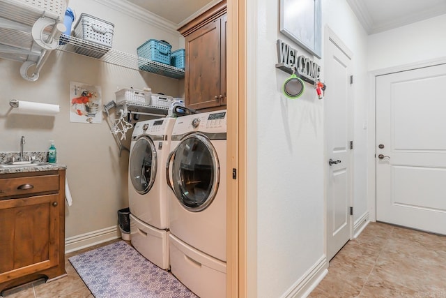 laundry area with crown molding, sink, cabinets, and independent washer and dryer