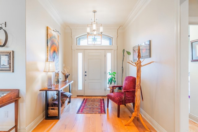 foyer entrance featuring light hardwood / wood-style floors, an inviting chandelier, and crown molding