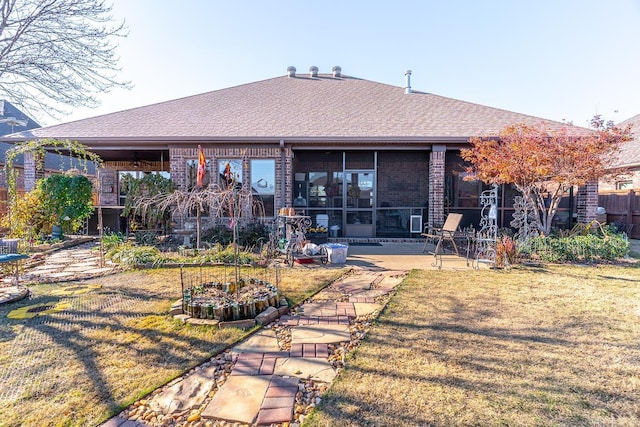 back of property with a lawn and a patio area