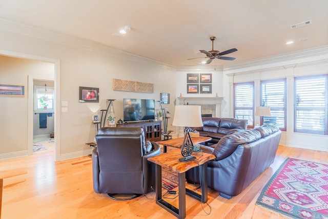 living room featuring ceiling fan, ornamental molding, and light hardwood / wood-style flooring