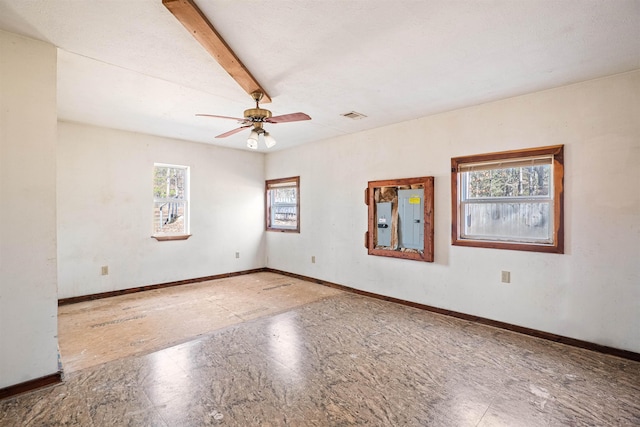 spare room with ceiling fan, electric panel, baseboards, and beam ceiling