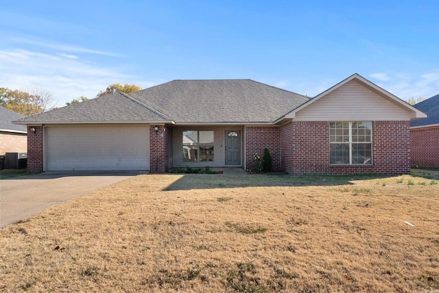 ranch-style home featuring a front lawn, cooling unit, and a garage