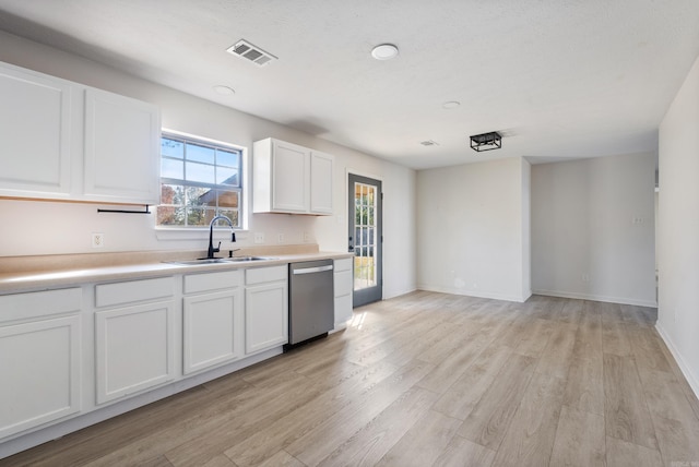 kitchen featuring white cabinetry, sink, stainless steel dishwasher, and light hardwood / wood-style flooring