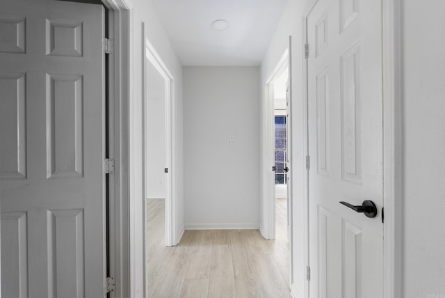 hallway with light hardwood / wood-style floors