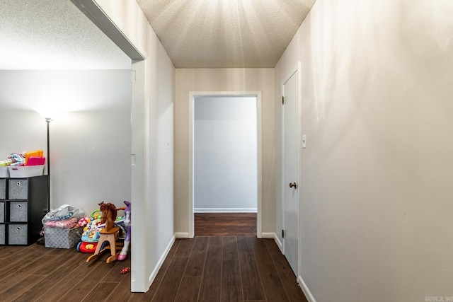 hall with dark wood-type flooring and a textured ceiling