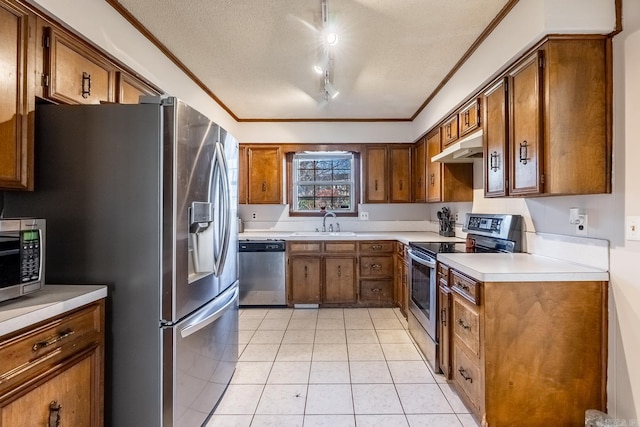 kitchen featuring sink, crown molding, a textured ceiling, light tile patterned flooring, and appliances with stainless steel finishes