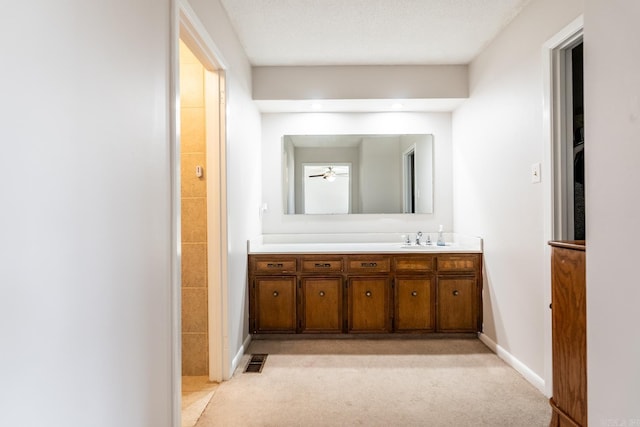 bathroom with ceiling fan, a textured ceiling, and vanity