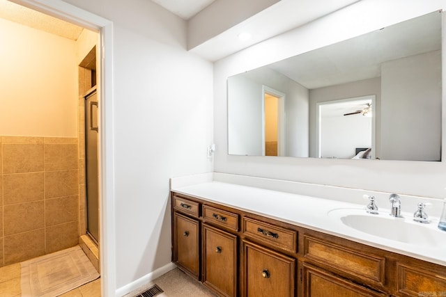 bathroom featuring tile patterned floors, ceiling fan, vanity, and a shower with shower door