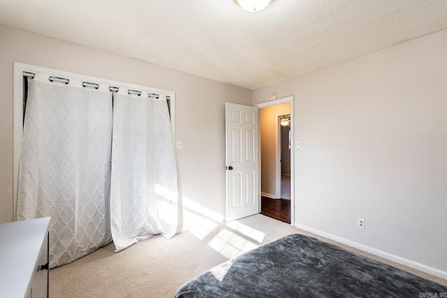 bedroom with light carpet and a textured ceiling