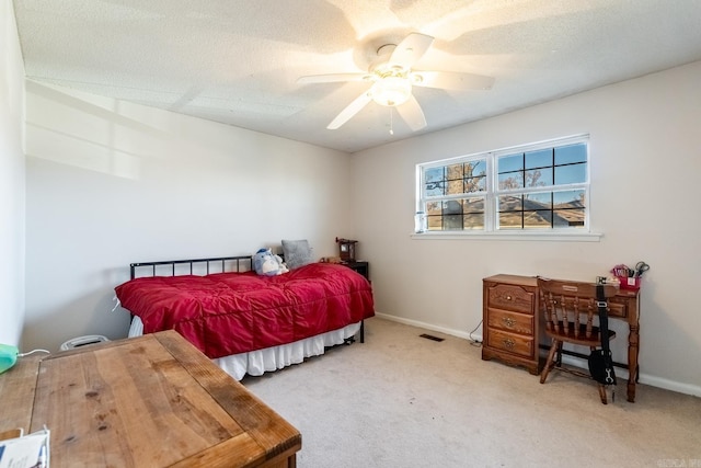 carpeted bedroom with ceiling fan and a textured ceiling