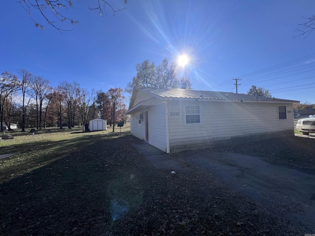 view of side of home featuring a storage shed
