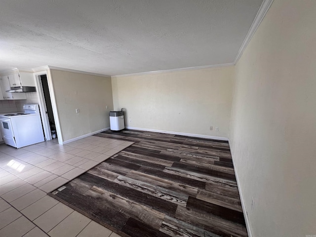 spare room featuring a textured ceiling, hardwood / wood-style flooring, and ornamental molding