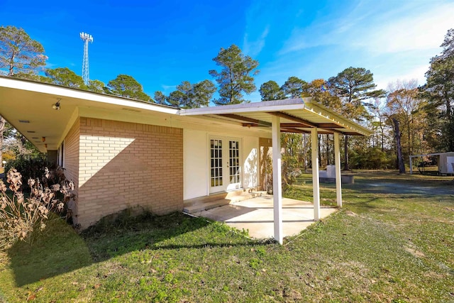 back of property with a yard and french doors