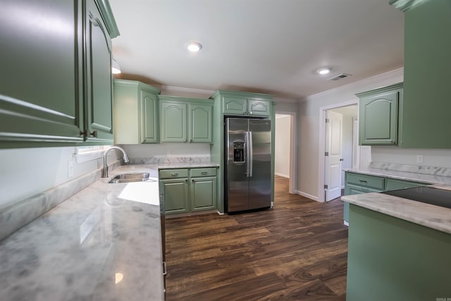 kitchen with dark hardwood / wood-style floors, green cabinets, stainless steel fridge with ice dispenser, and sink