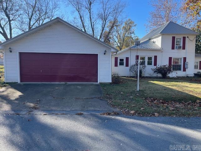 920 N Williams, Carlisle, AR 72024 - view of front of property with a front yard, metal roof, cooling unit, and a garage