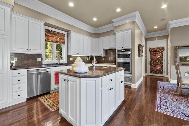 kitchen featuring white cabinets, dark hardwood / wood-style flooring, stainless steel appliances, and a center island with sink